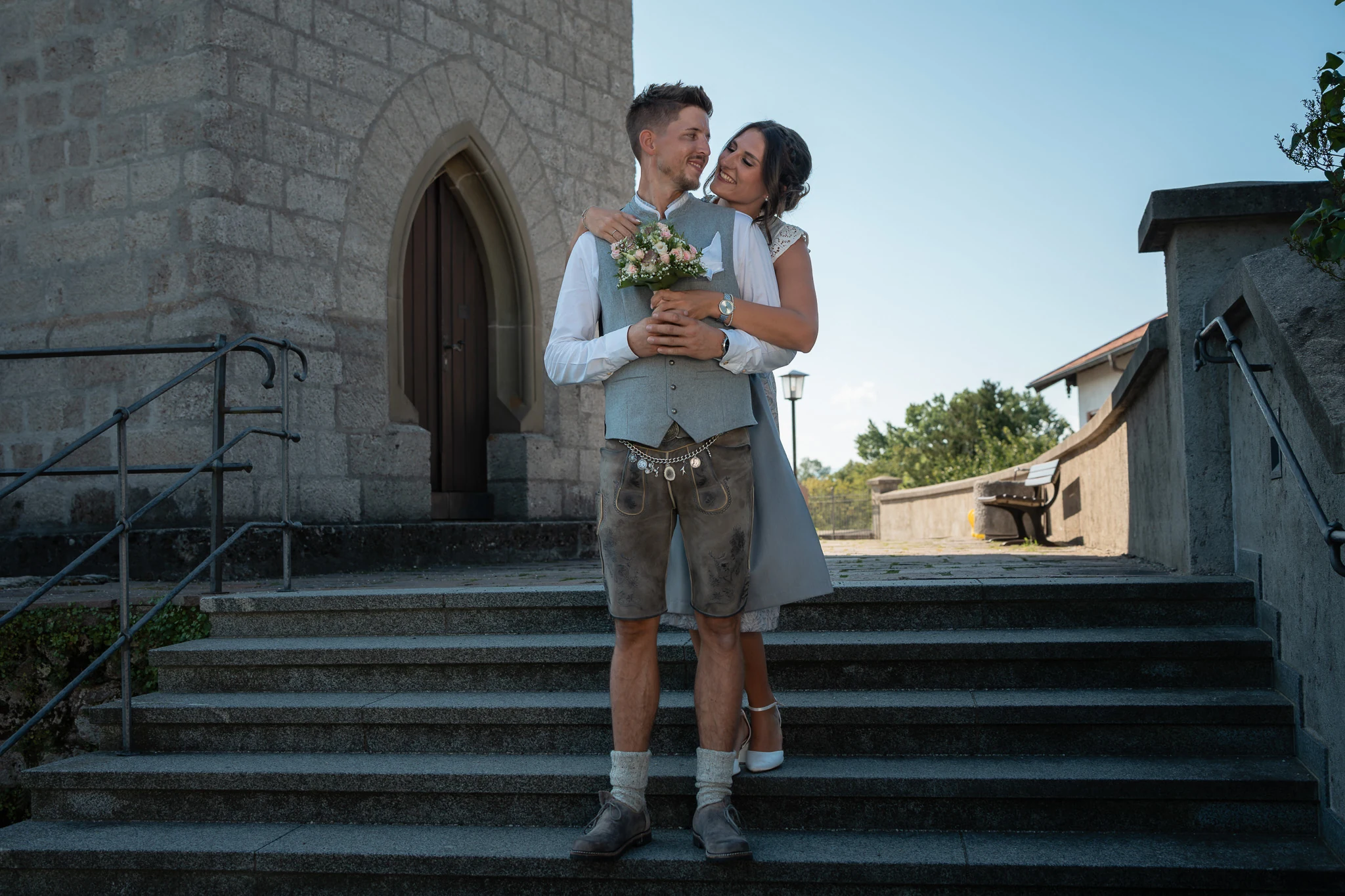Brautpaar auf einer Treppe nach der Hochzeit in Seebruck