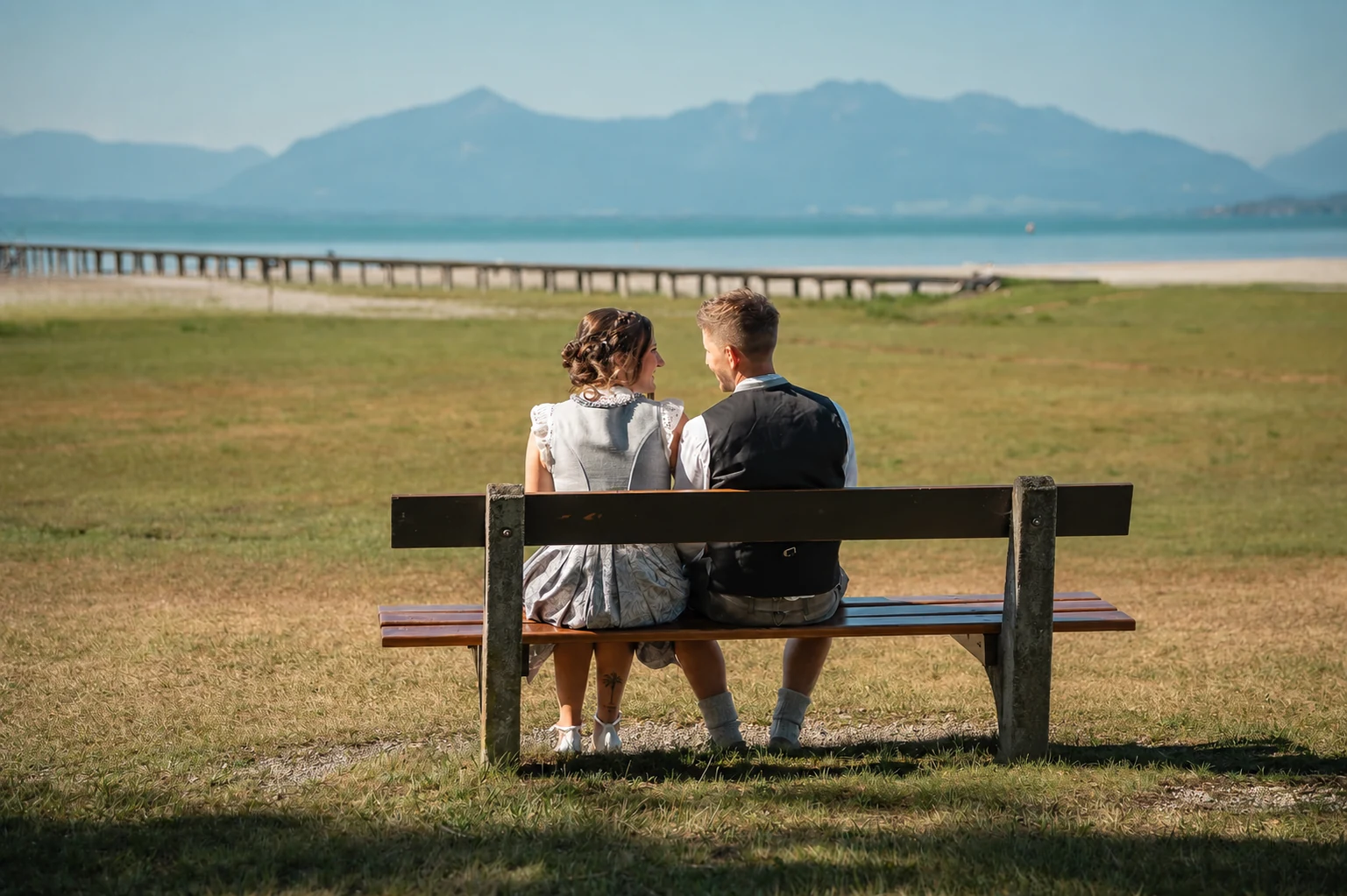 Brautpaar am Chiemsee in Seebruck mit Blick auf die Chiemgauer Alpen und Kampenwand