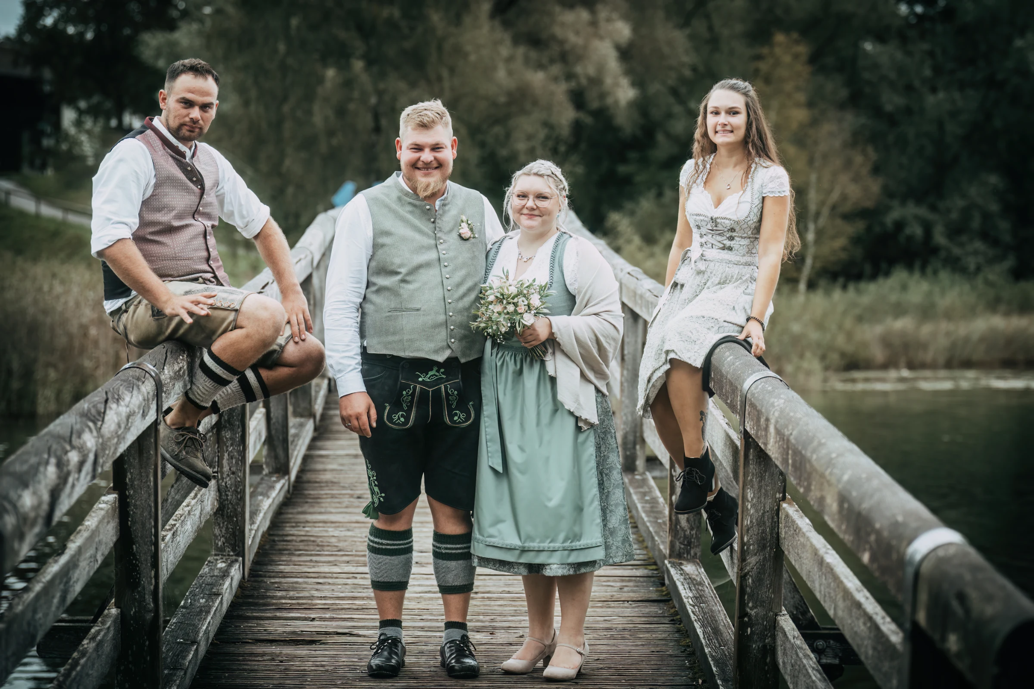 Hochzeitsgesellschaft auf einer Holzbrücke am Kloster Seeon