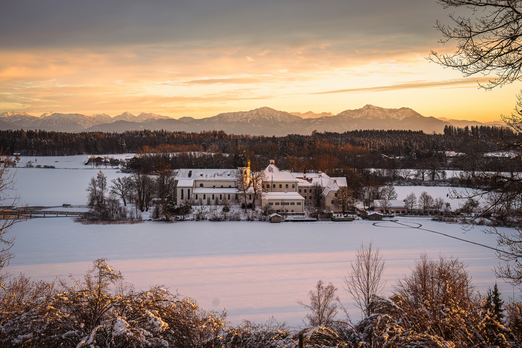 Kloster Seeon in winterlicher Landschaft mit Blick auf die Chiemgauer Alpen