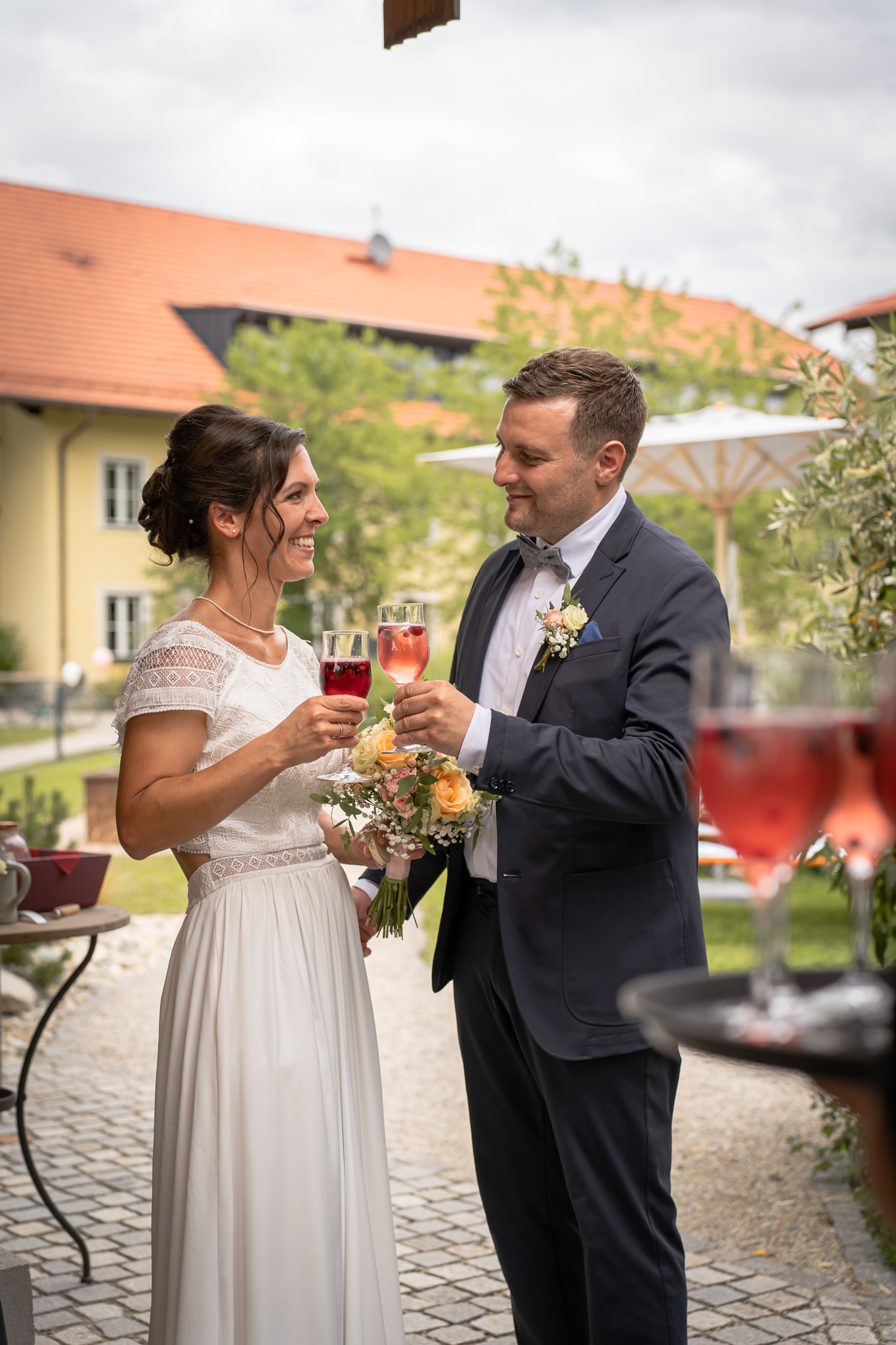 Brautpaar stößt beim Hochzeitsempfang gemeinsam an