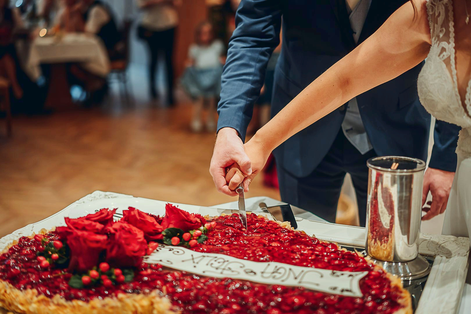 Brautpaar beim gemeinsamen Anschneiden der Hochzeitstorte