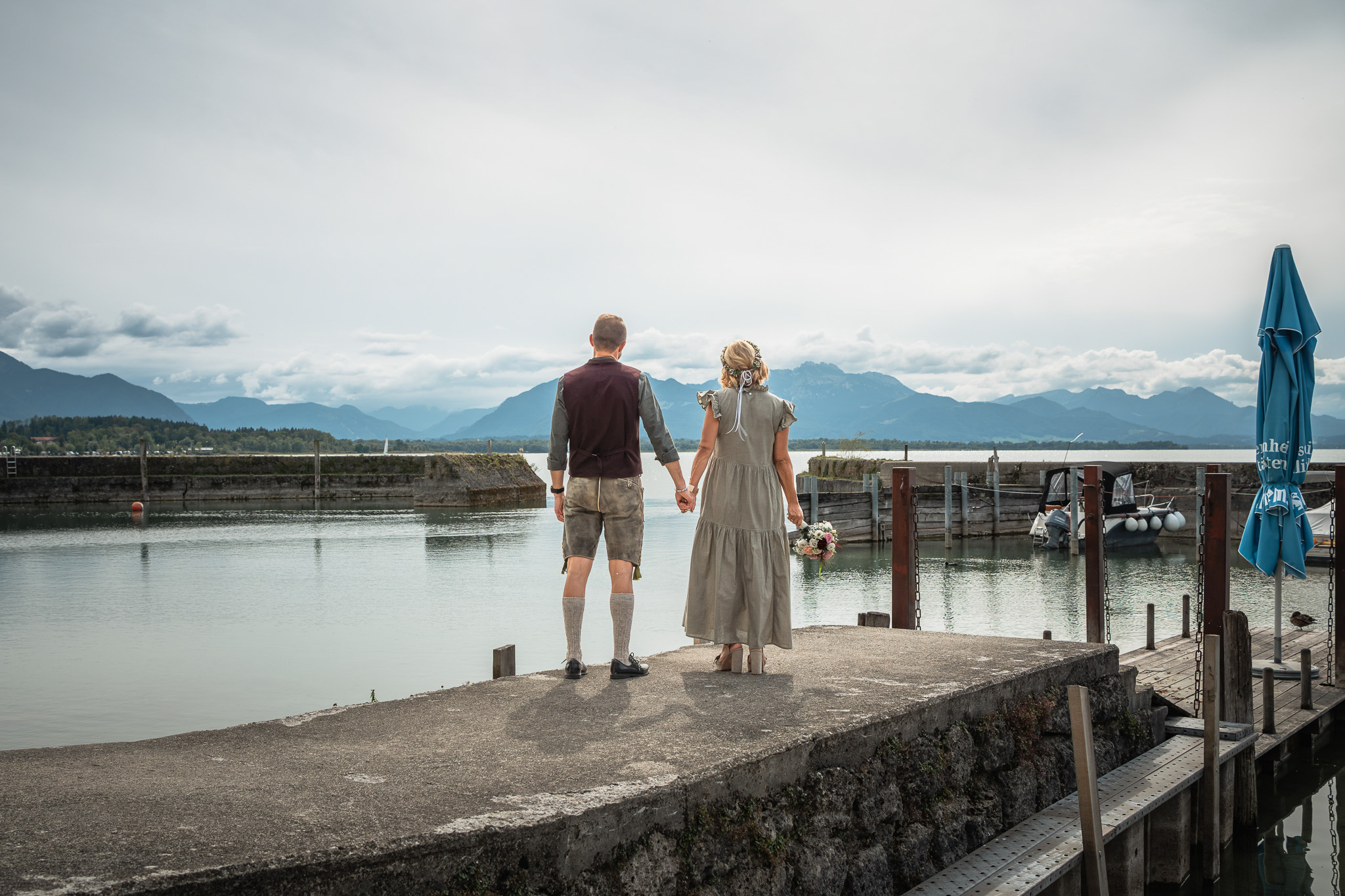 Brautpaar am Chiemsee mit weitem Blick auf die Chiemgauer Alpen