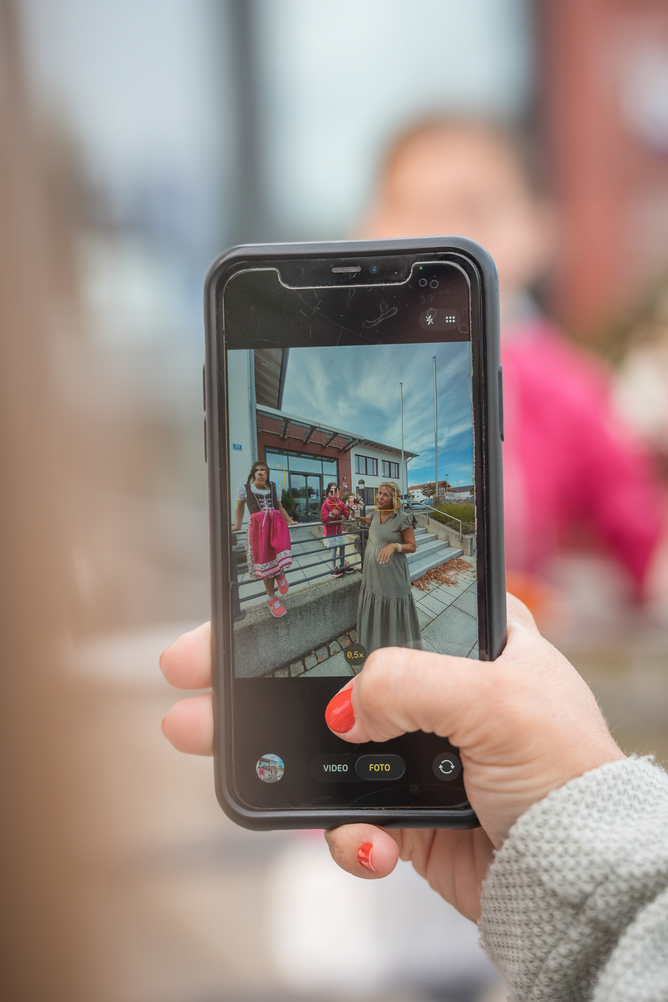 Hochzeitsgast hält die fröhlichen Momente vor dem Standesamt Chieming mit dem Smartphone fest