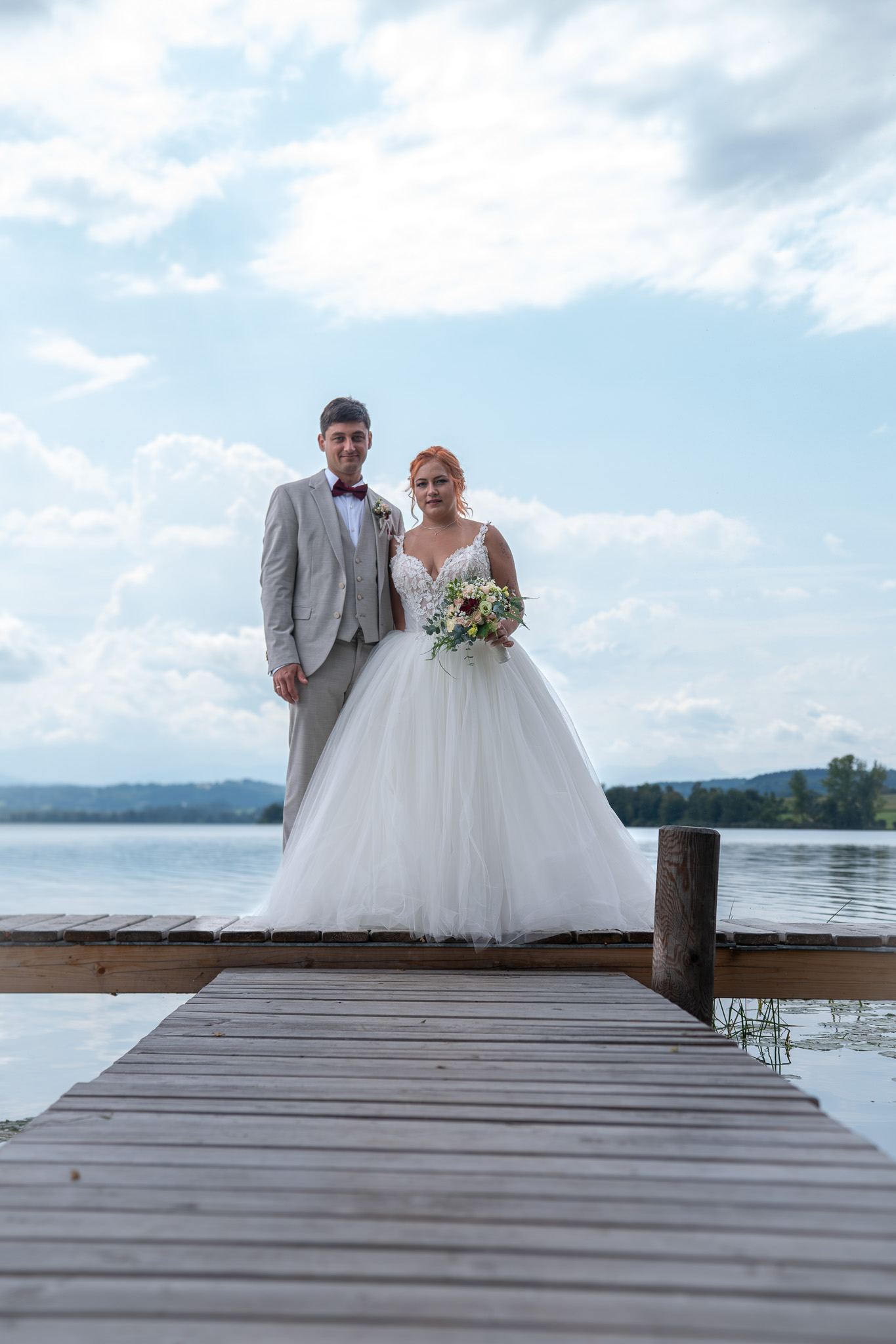 Brautpaar auf einem Steg am See während seiner Hochzeitsreportage.