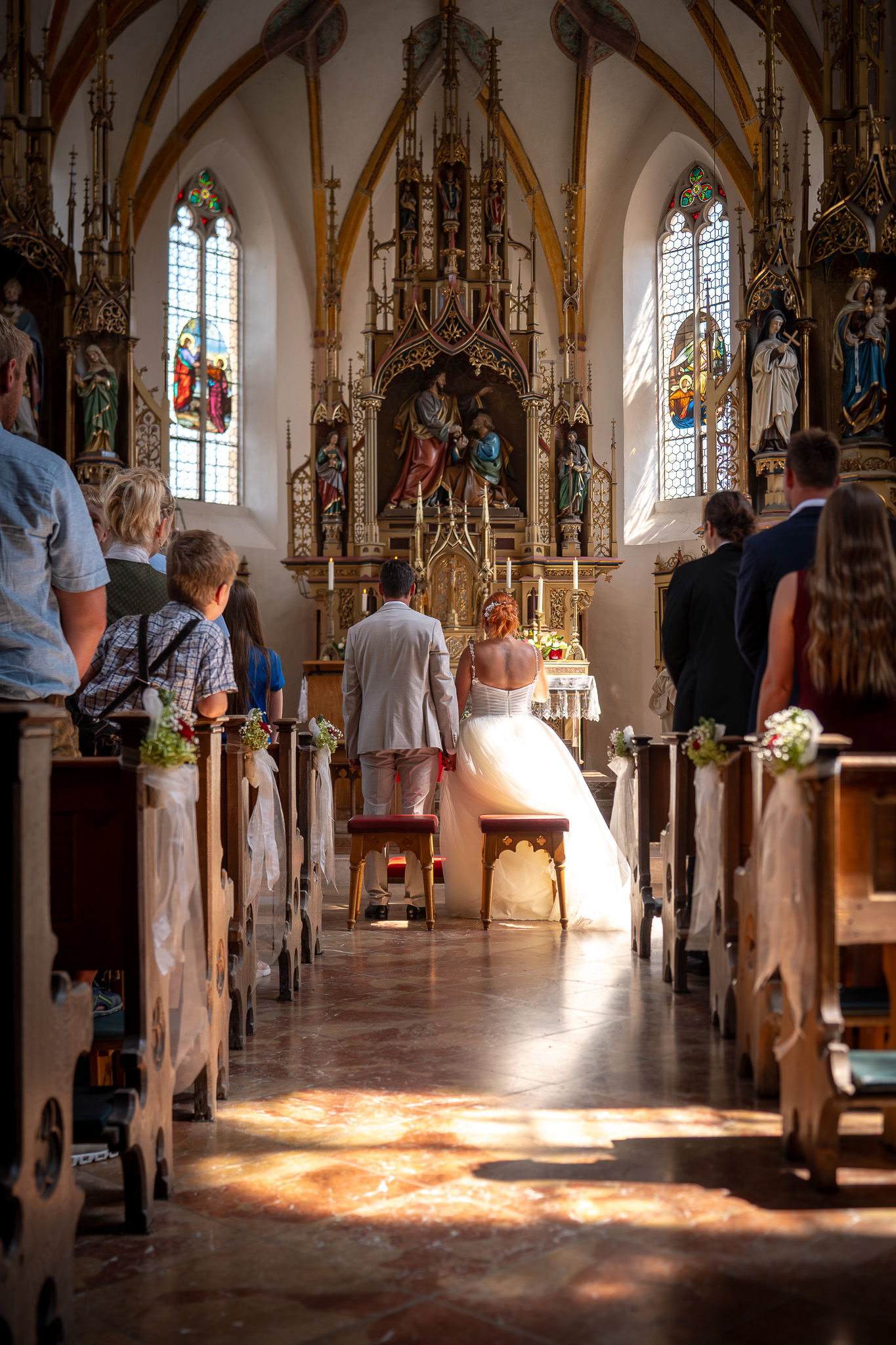 Das Brautpaar zieht gemeinsam durch den Mittelgang in die Kirche ein.