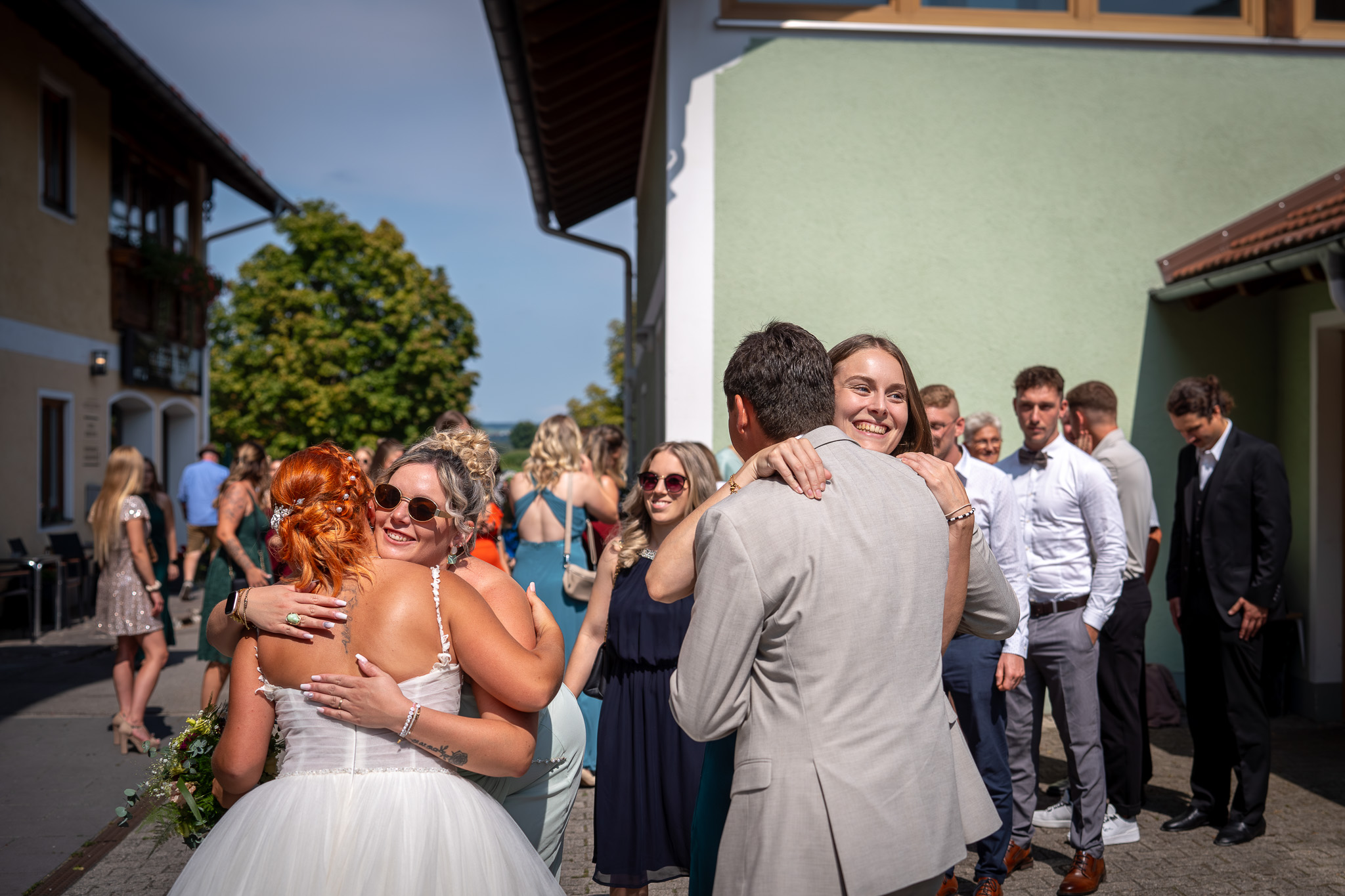 Gäste gratulieren dem frisch verheirateten Paar beim Sektempfang.