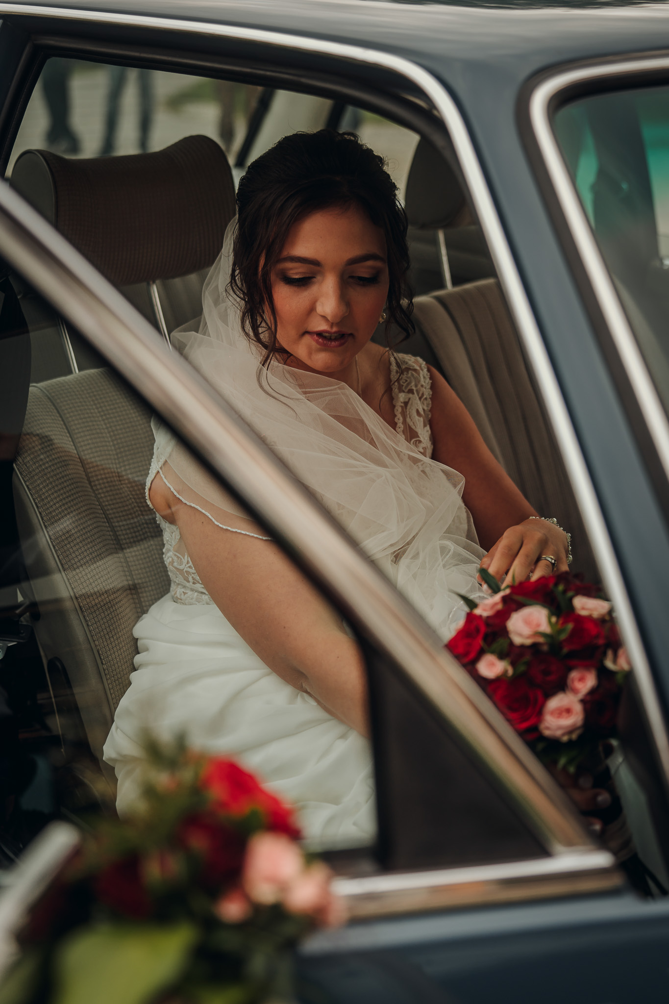 Die Braut sitzt im Auto auf dem Weg zur Hochzeit im Kloster Seeon.