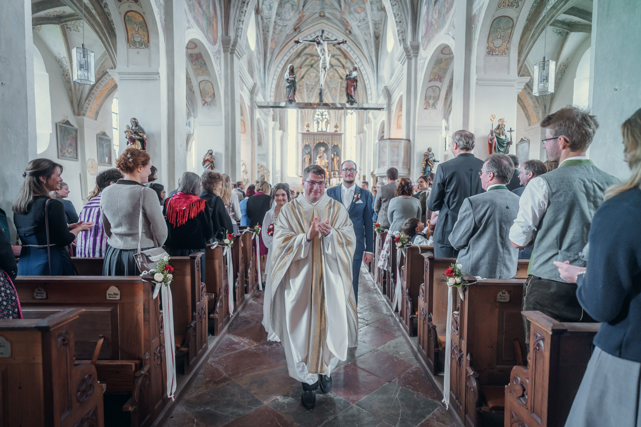 Feierlicher Auszug des Brautpaares durch die Reihen der Hochzeitsgäste im Kloster Seeon.