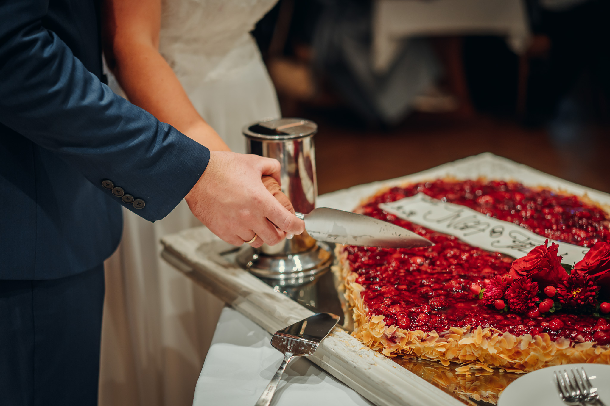 Beim Anschneiden der Hochzeitstorte zeigt sich augenzwinkernd, wessen Hand oben liegt.