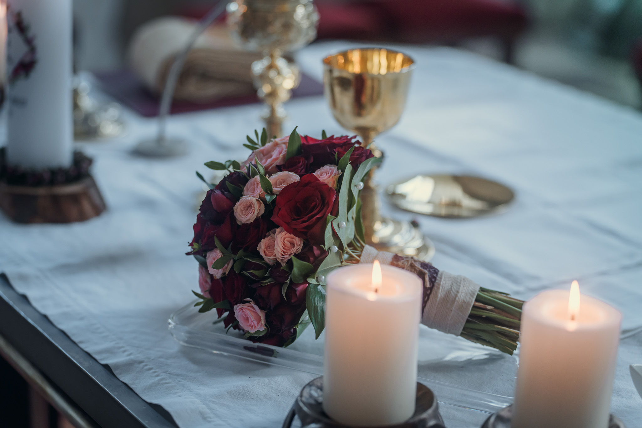 Brautstrauß mit roten und rosafarbenen Rosen auf dem Altar im Kloster Seeon