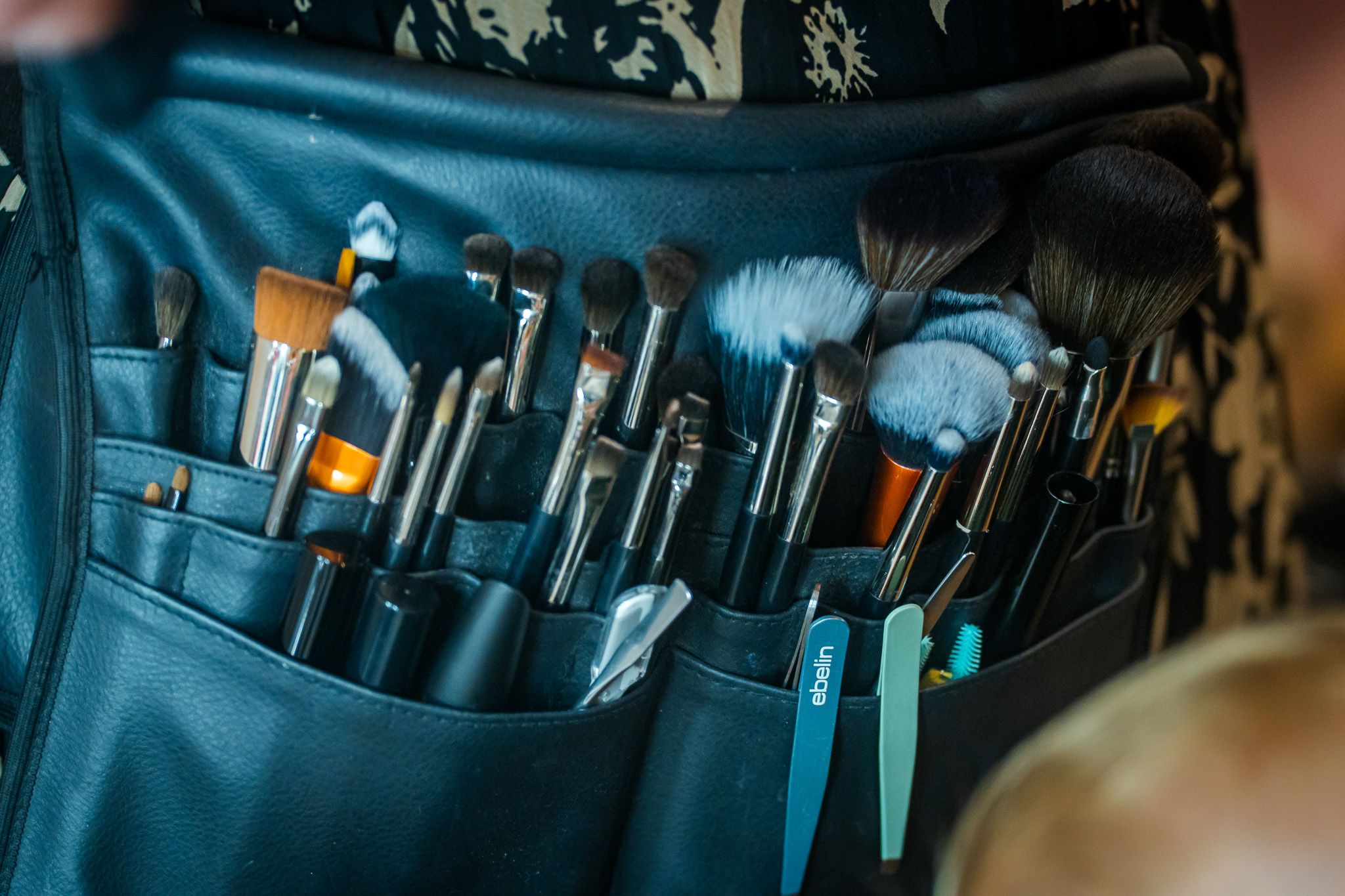 Arbeitsgürtel der Stylistin mit Pinseln und Make-up-Utensilien beim frühen Getting Ready.