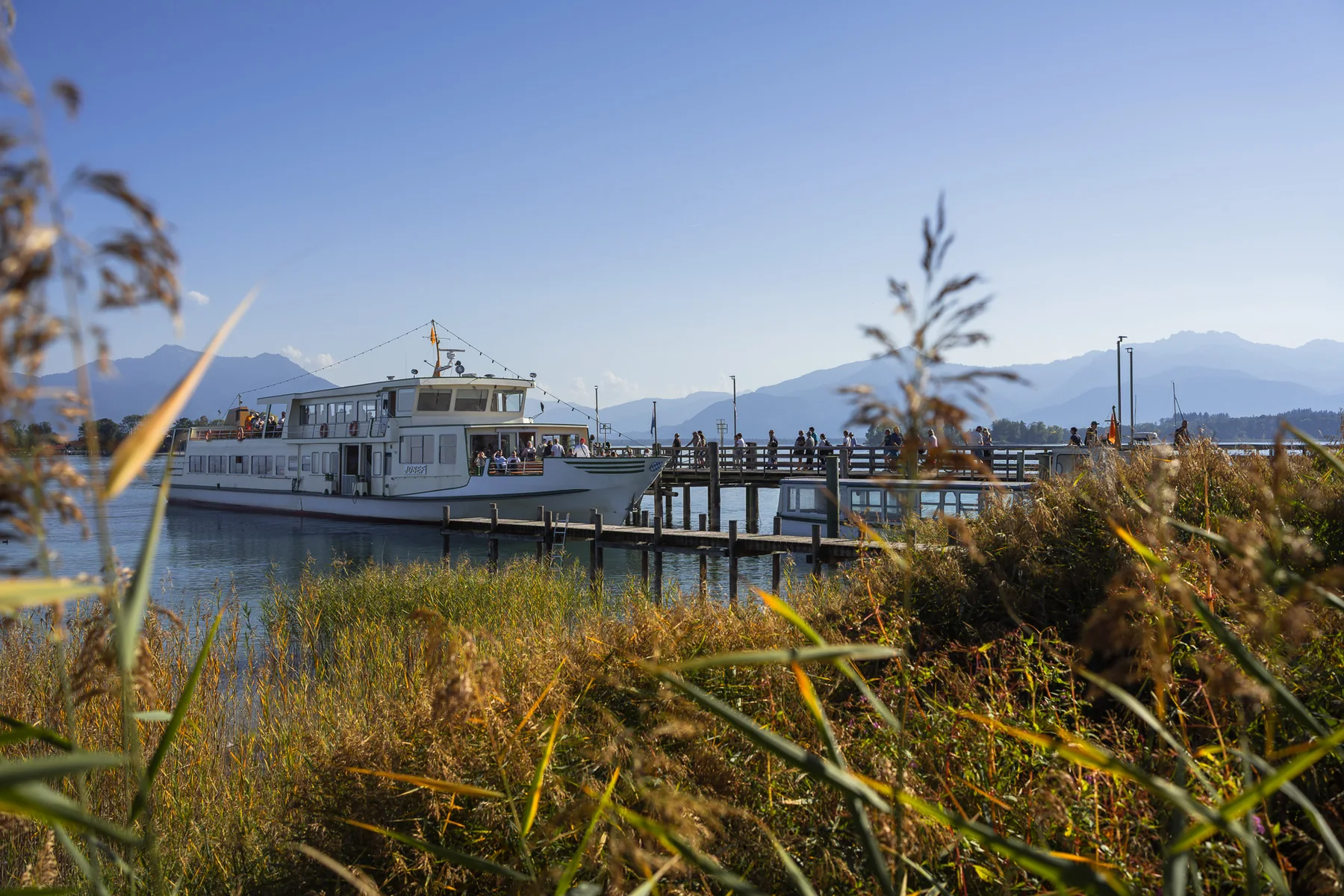 Dampfersteg Gstadt – Chiemsee-Schifffahrt Richtung Inseln Chiemsee-Schifffahrt am Dampfersteg in Gstadt mit den Chiemgauer Alpen im Hintergrund