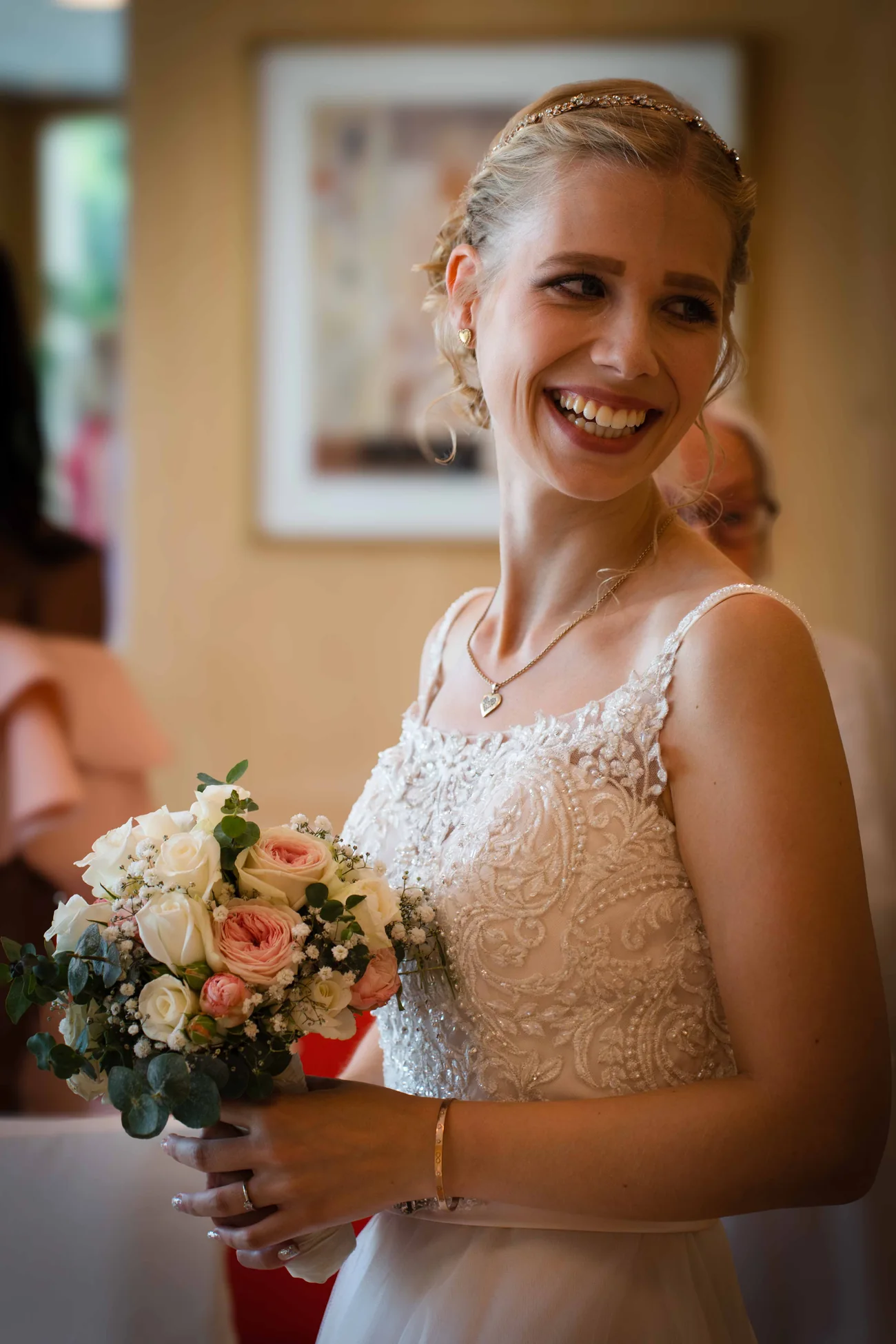 Braut mit Brautstrauß im Standesamt Lächelnde Braut mit Blumenstrauß im hellen Trauzimmer