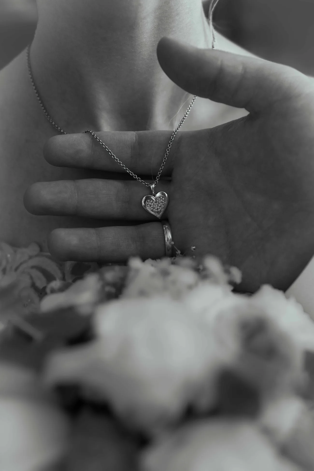 Brautschmuck und kleine Details Schwarz-Weiß-Nahaufnahme von Halskette und Händen der Braut