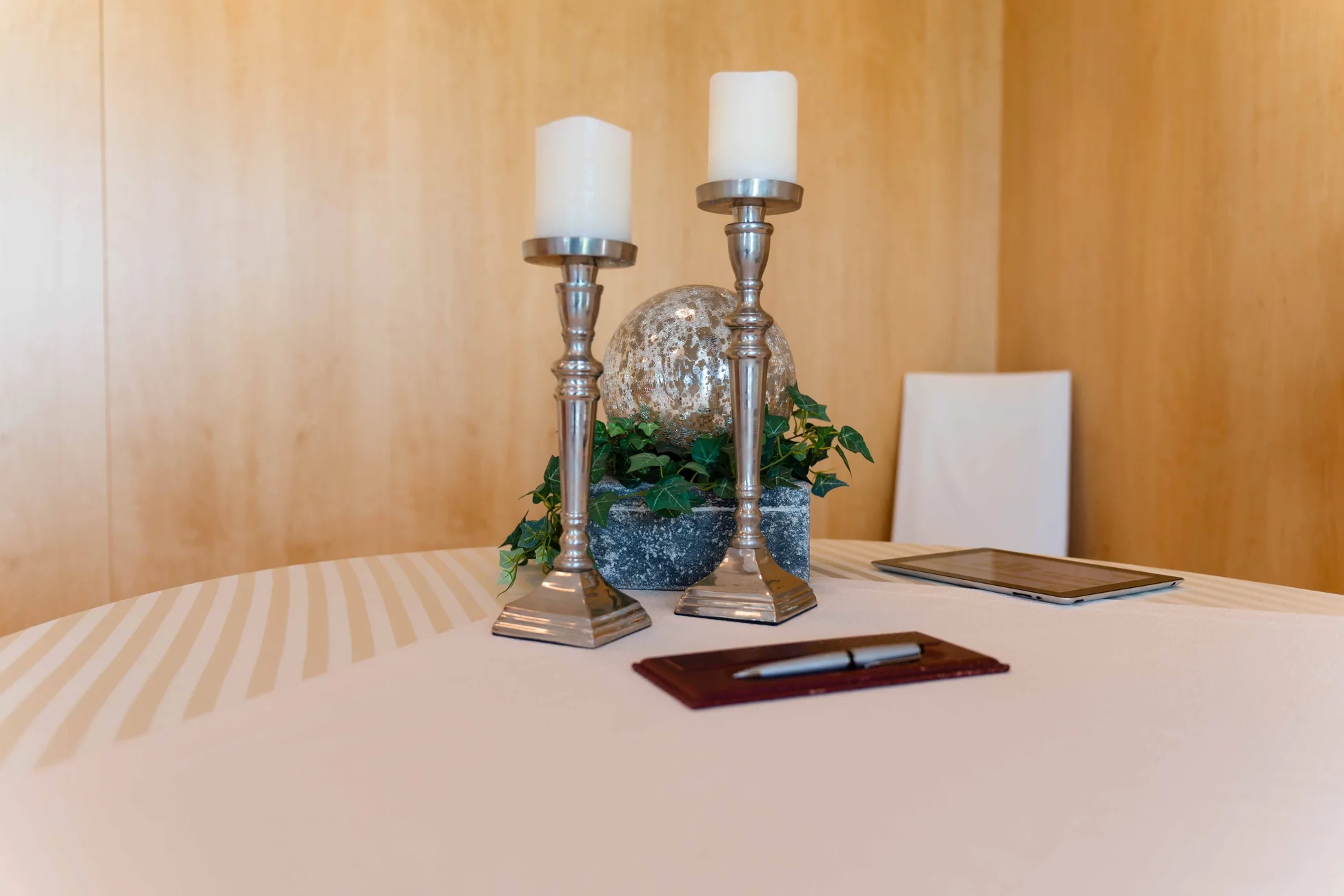 Dekoration im Trauzimmer Traunreut Festlich vorbereiteter Tisch mit Kerzen, Blumenschmuck und Unterlagen im Trauzimmer