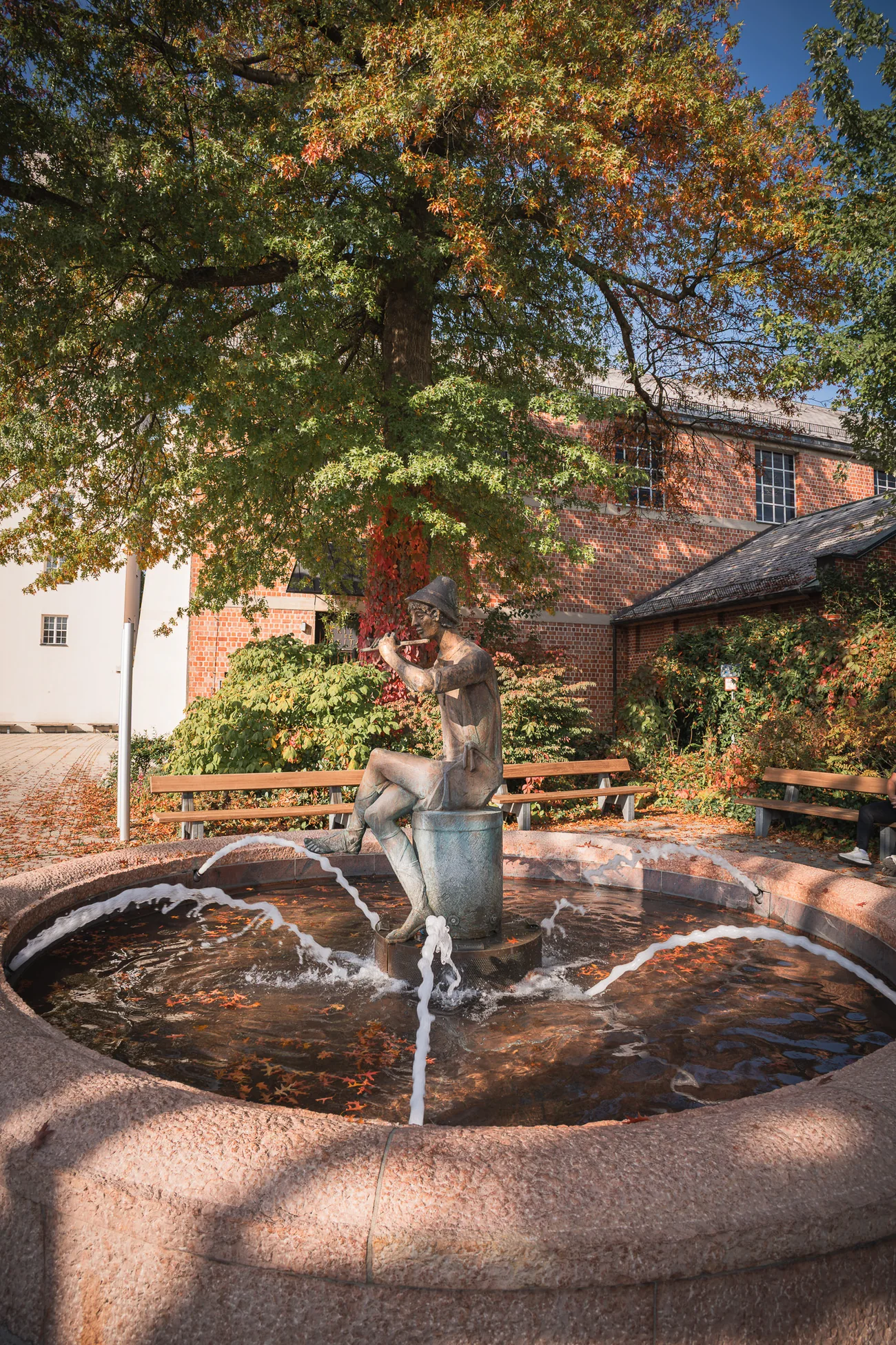 Brunnen im Zentrum von Traunreut Kleiner Brunnen unter einem Baum im Zentrum von Traunreut